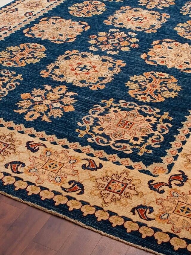 Teppich mit dunkelblauem Feld, sandfarbenen Blütenornamenten und breiter sandfarbener Bordüre